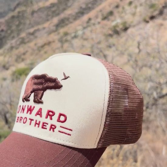 Video of someone holding the Brown Bear Trucker Hat and showing inside and outside of it with Big Bend mountains in the backgroud.