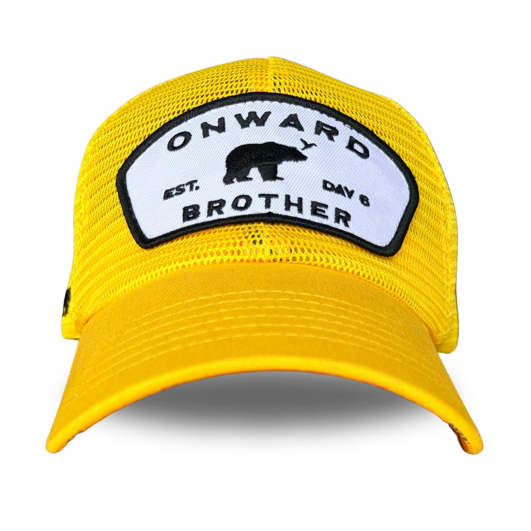 A bright yellow trucker hat with a white and black embroidered patch on the front that reads 'ONWARD BROTHER, est day 6' with a black bear silhouette.