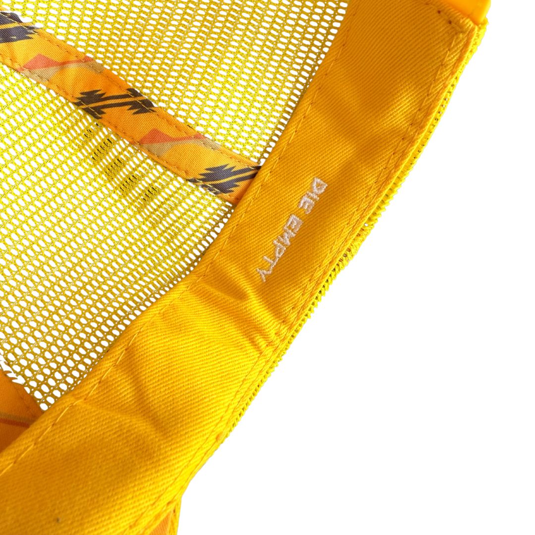 Close-up detail of a bright yellow mesh hat with a yellow fabric trim and white printed text reading 'DIE EMPTY'.